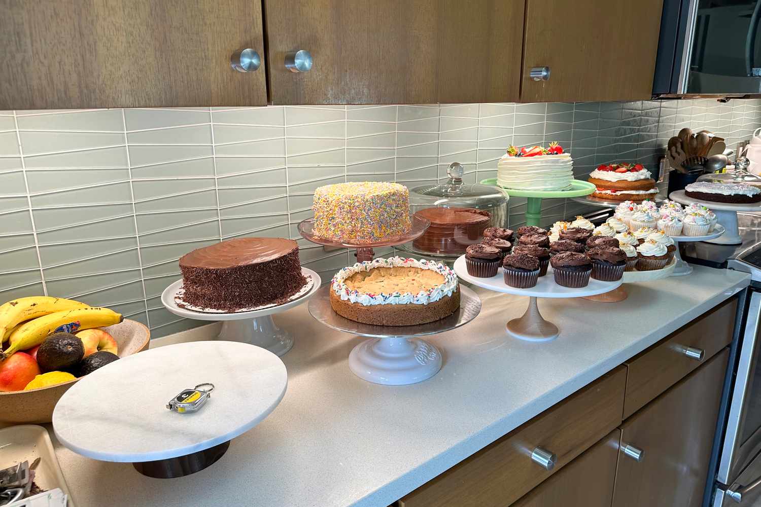 A collection of cake stands, all containing baked goods, sits on a countertop