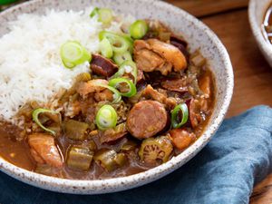 Bowl of Cajun gumbo with chicken, okra, and andouille sausage that is served with rice.