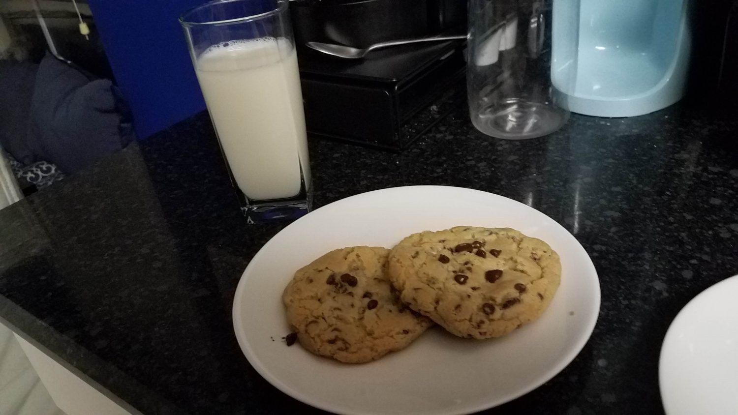 Stella's chocolate chip cookies on a plate flanked by a glass of milk