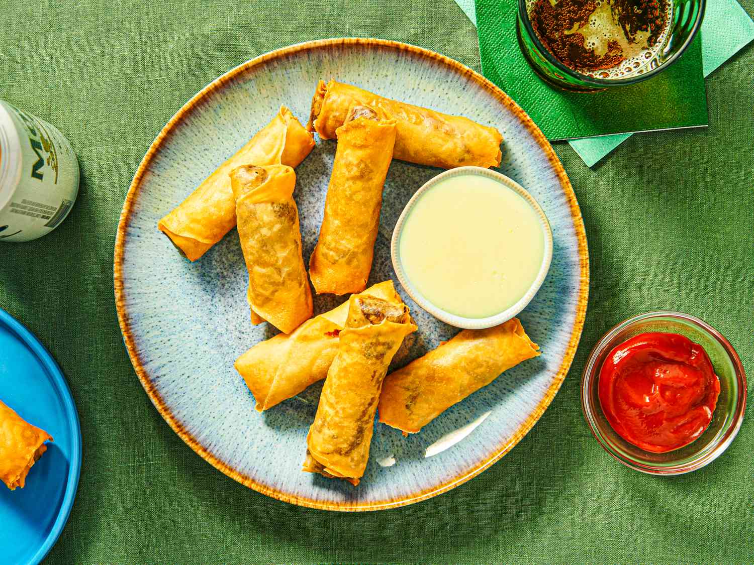 Overhead view of dipping cheesesteak eggroll into cheese sauce