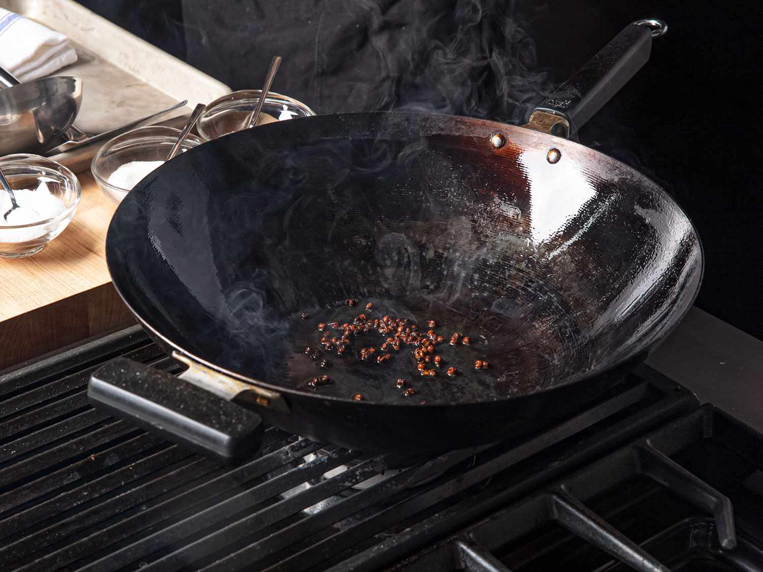 Sichuan peppercorns in a seasoned smoking wok.