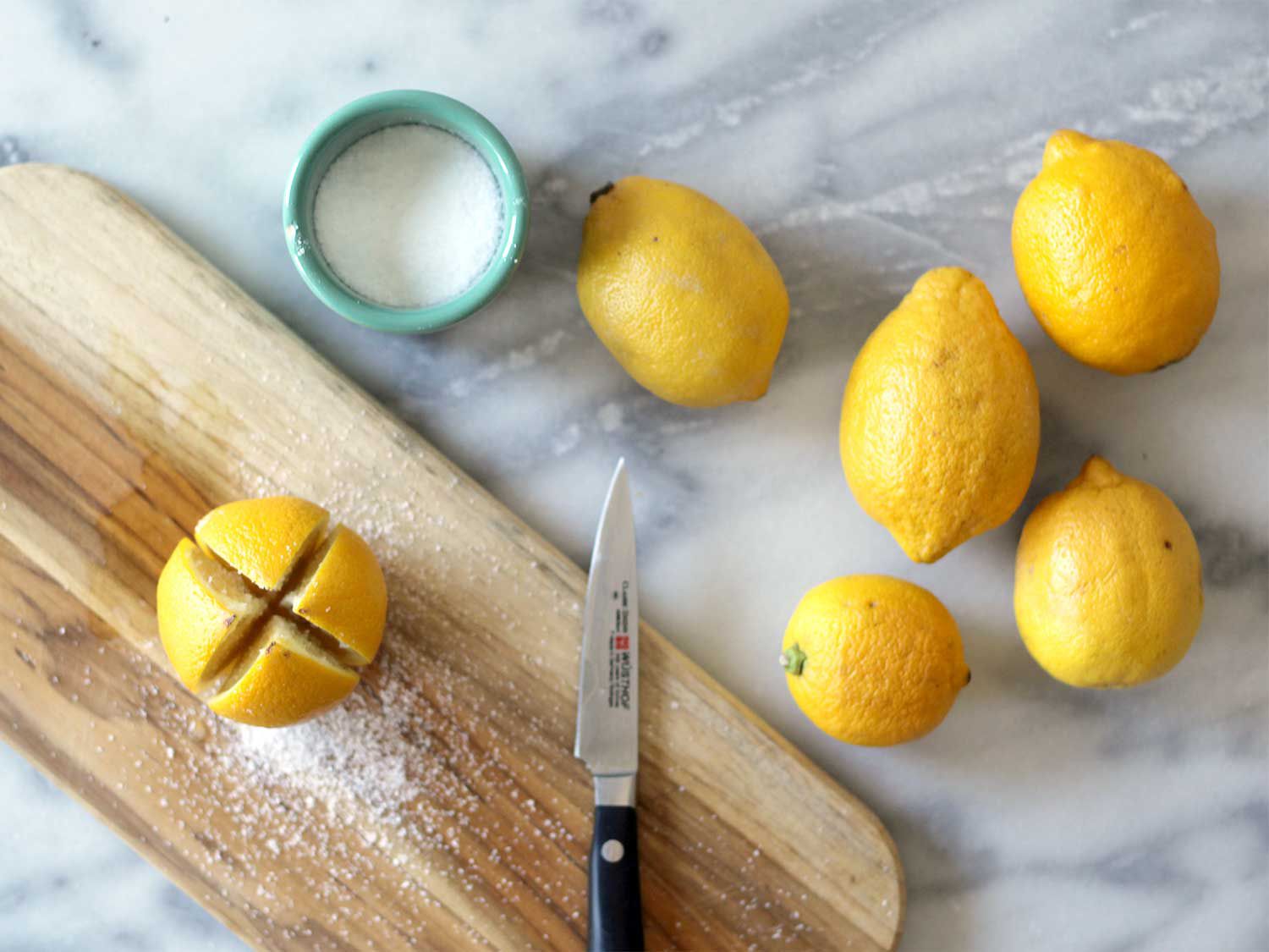 Process of cutting and coating lemons in salt and sugar for preserving