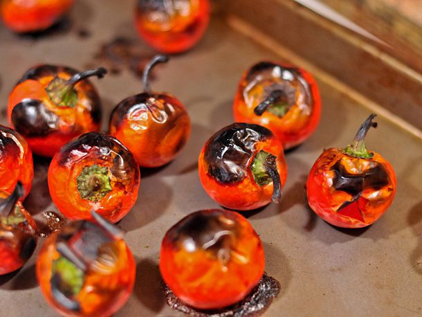 Closeup of roasted cherry peppers, charred and ready to rest.
