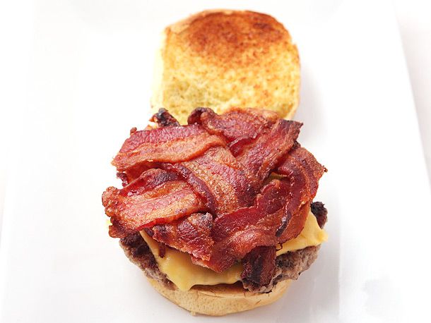 A cheeseburger assembled with a perfectly sized layer of "bacon weave" on top.