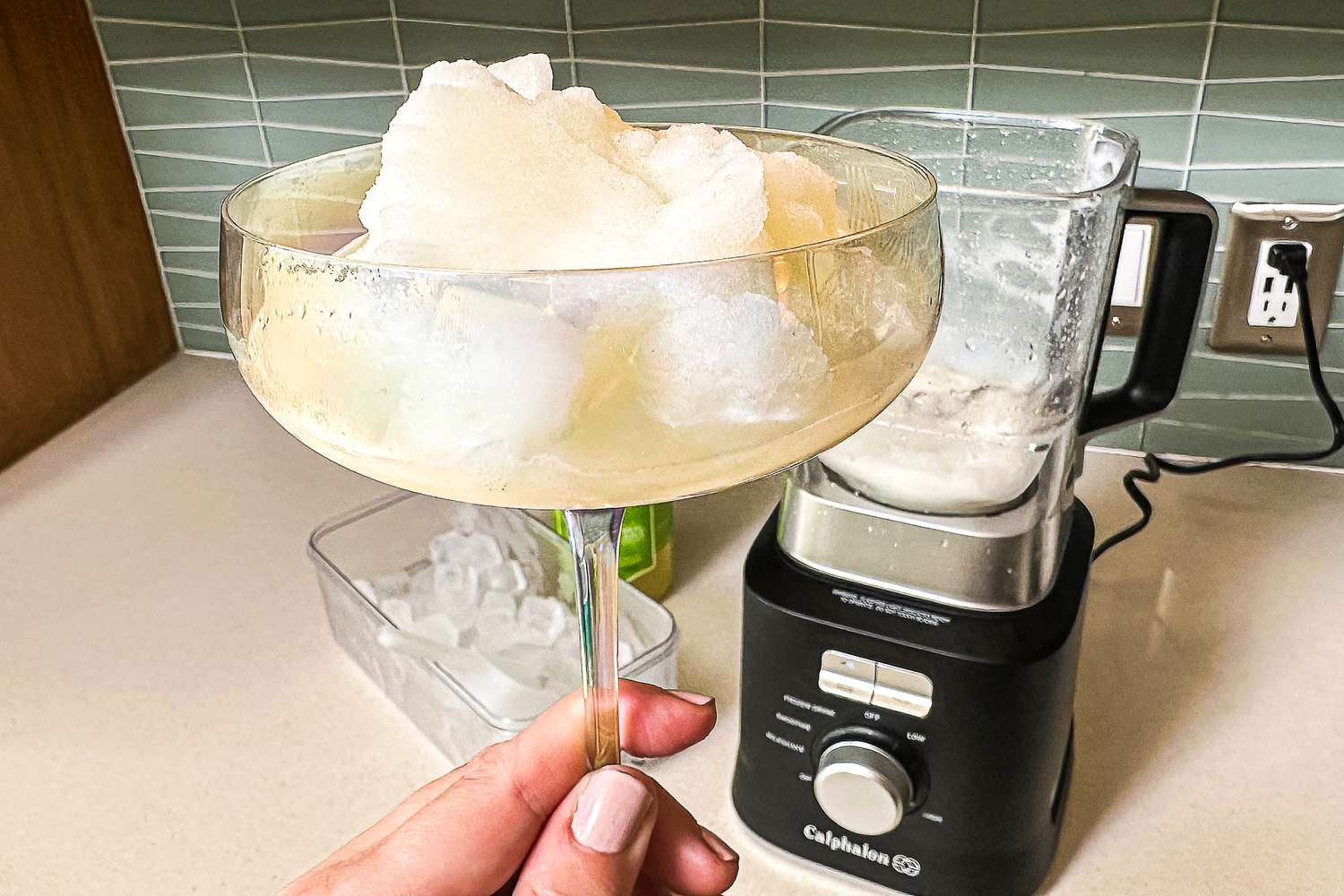 A freshly made frozen margarita in a glass with the Calphalon Precision Blender in the background