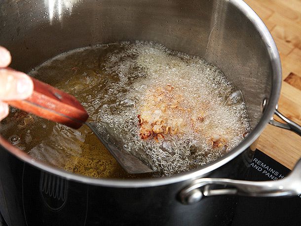Ramen-crusted chicken frying in a pot.