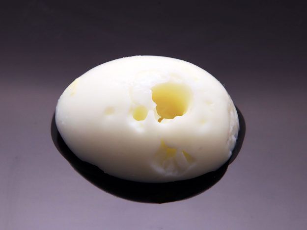 Boiled egg with a large crater in egg white.