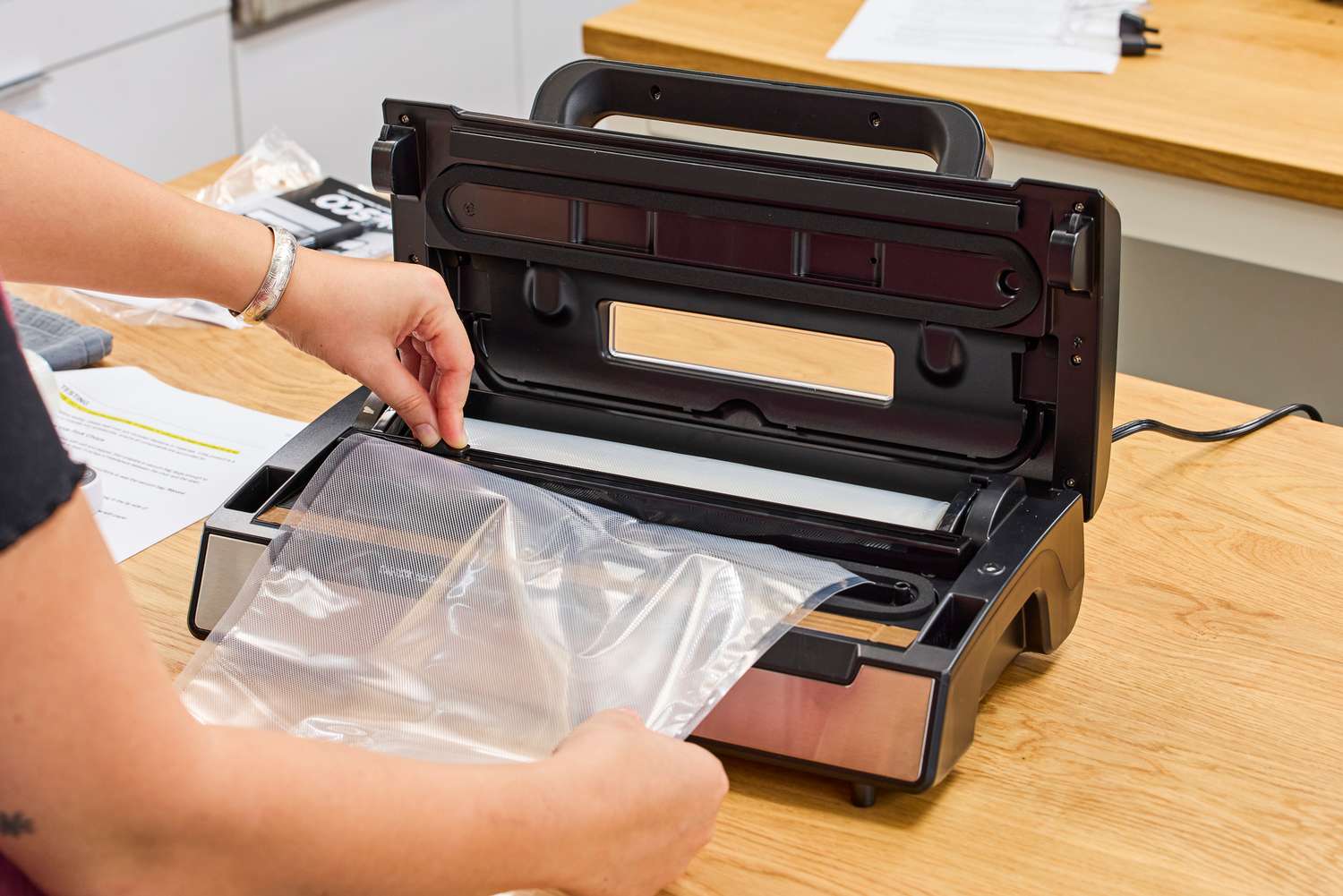 A person creates a plastic bag from the Nesco VS-12 Deluxe Vacuum Sealer