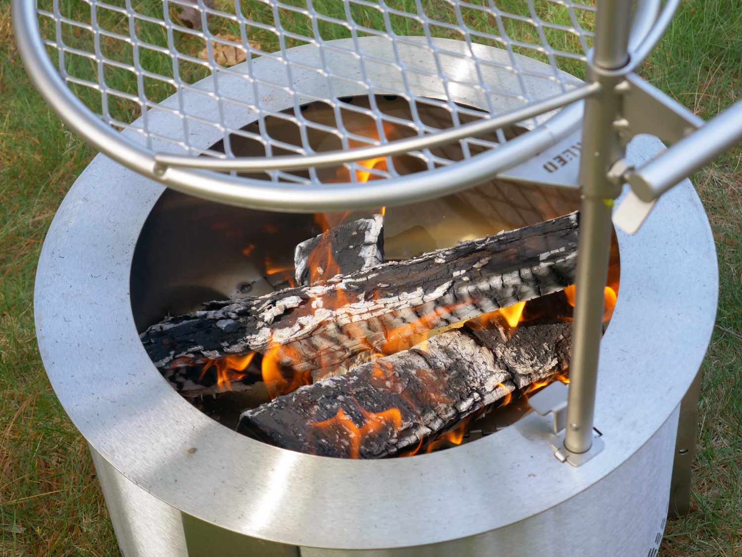 a closeup of the interior of the breeo fire pit with logs on fire