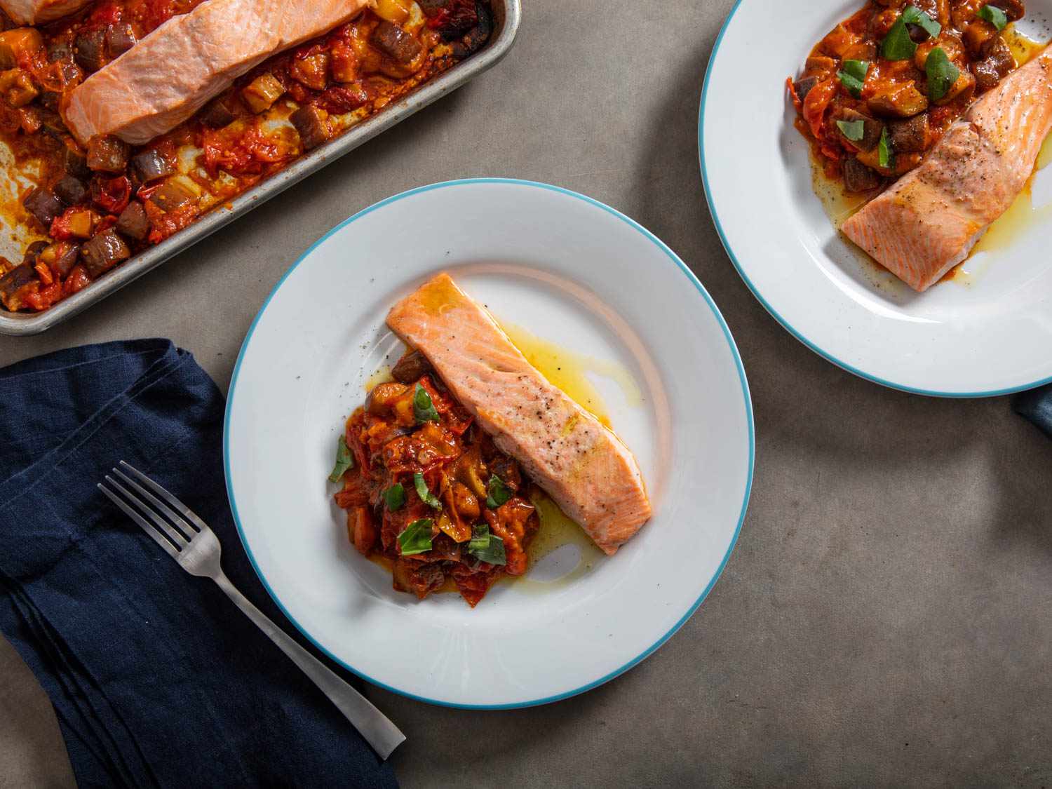 A sheet-pan dinner of salmon with roasted tomatoes and eggplant