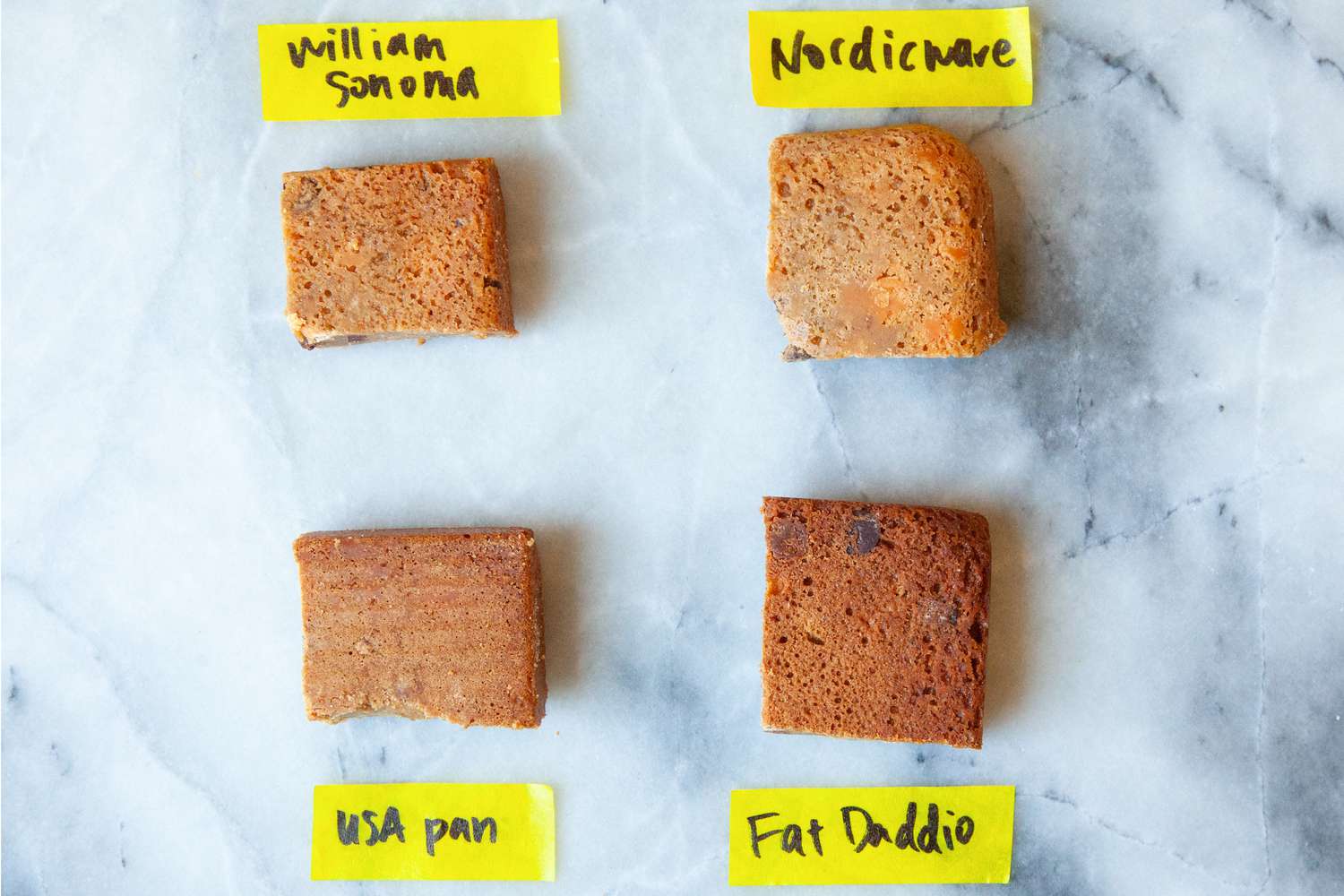 Four slices of cake on a marble countertop.