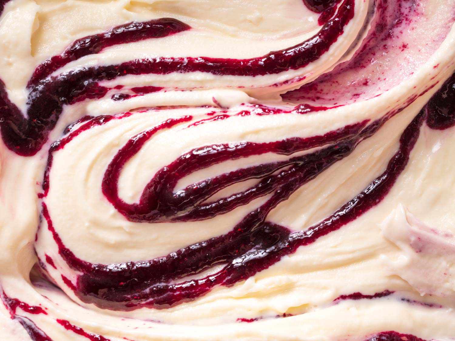 Close-up of ice cream swirled with thick fruit syrup.