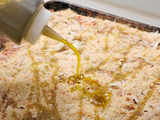 adding olive oil to pizza