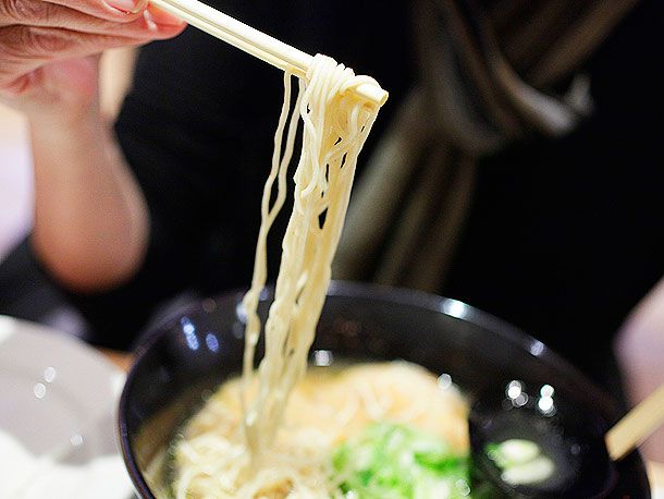 Ramen being pulled from a bowl with chopsticks.