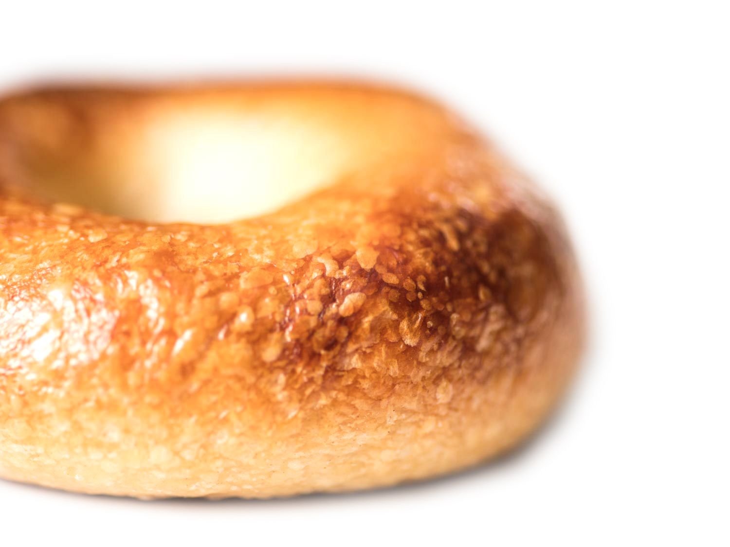 Closeup of the blistered surface of a freshly baked bagel.