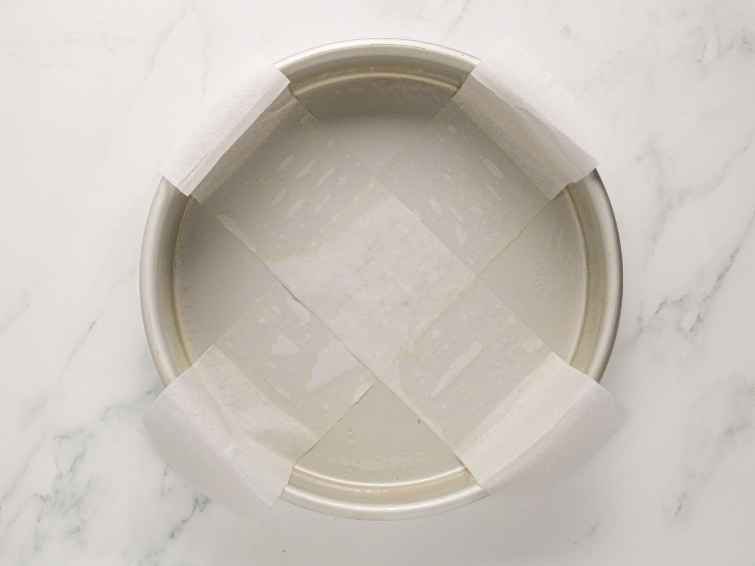 round baking pan with parchment paper over it in the form of an X