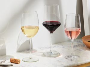 Three wine glasses filled with red, white, and rosé wine