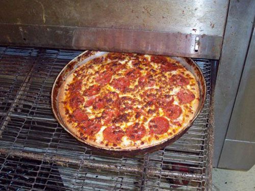 Pepperoni pizza coming out of the oven at Aver's Pizza in Bloomington, Indiana.