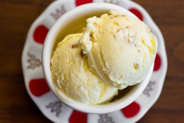 An overhead view of two scoops of buttered popcorn ice cream in a dish on a saucer.