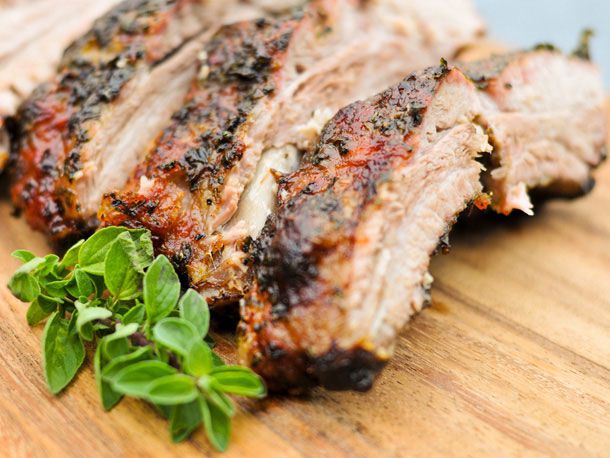 Herb-encrusted baby back ribs, cut into individual portions on a cutting board