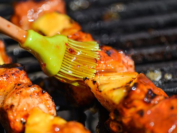 Closeup of the skewers being brushed with the apricot glaze.