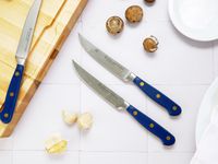 the wusthof steak knives on a white tile surface