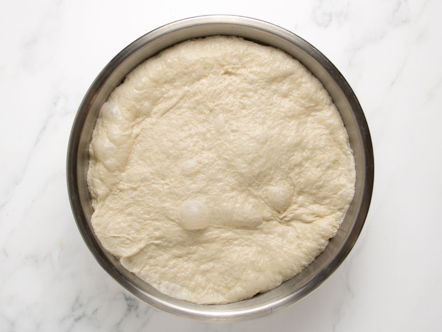 A bowl with prepared dough resting, ready for making Sfenj donuts