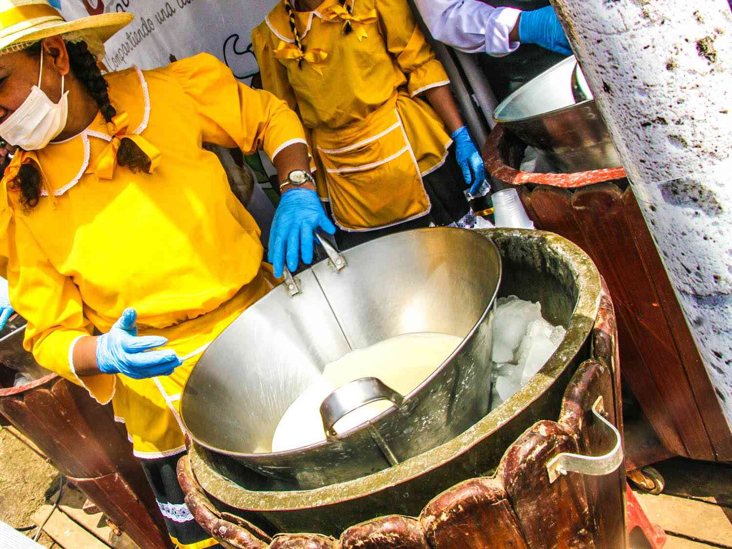 A vendor standing behind the vessel containing Ecuadorian ice cream, helado de paila.