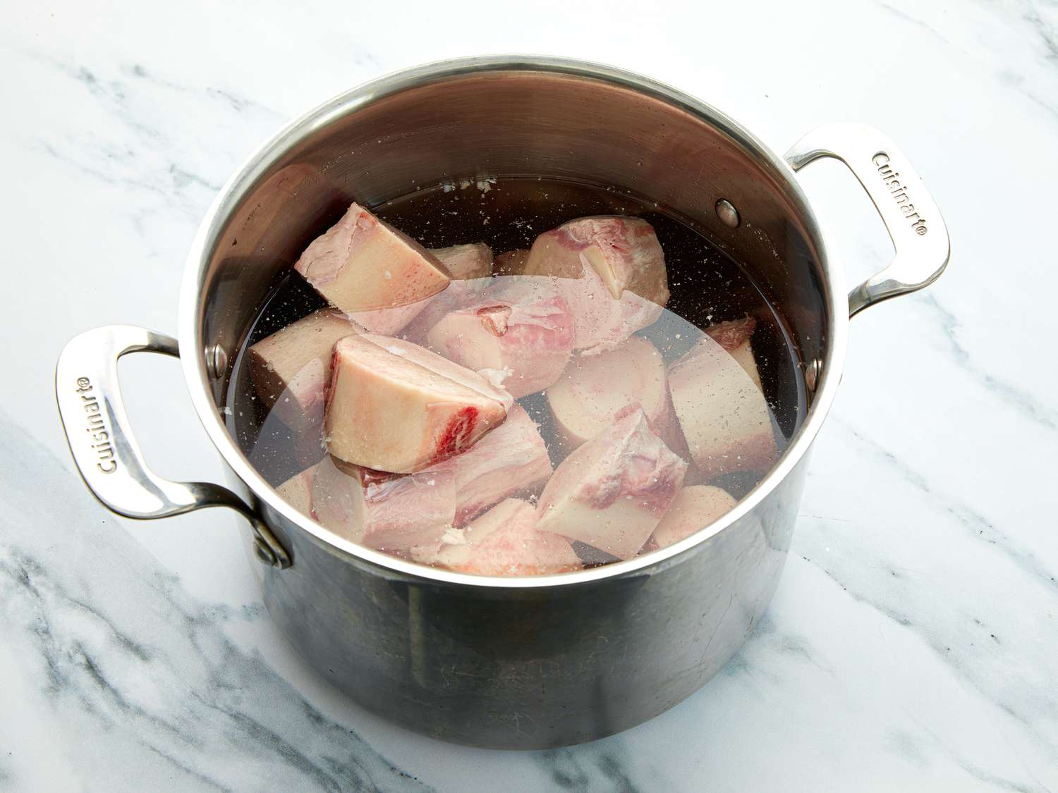 Bones in large stock pot on a marble surface 