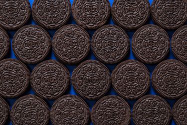 Oreos neatly lined up on a blue background.