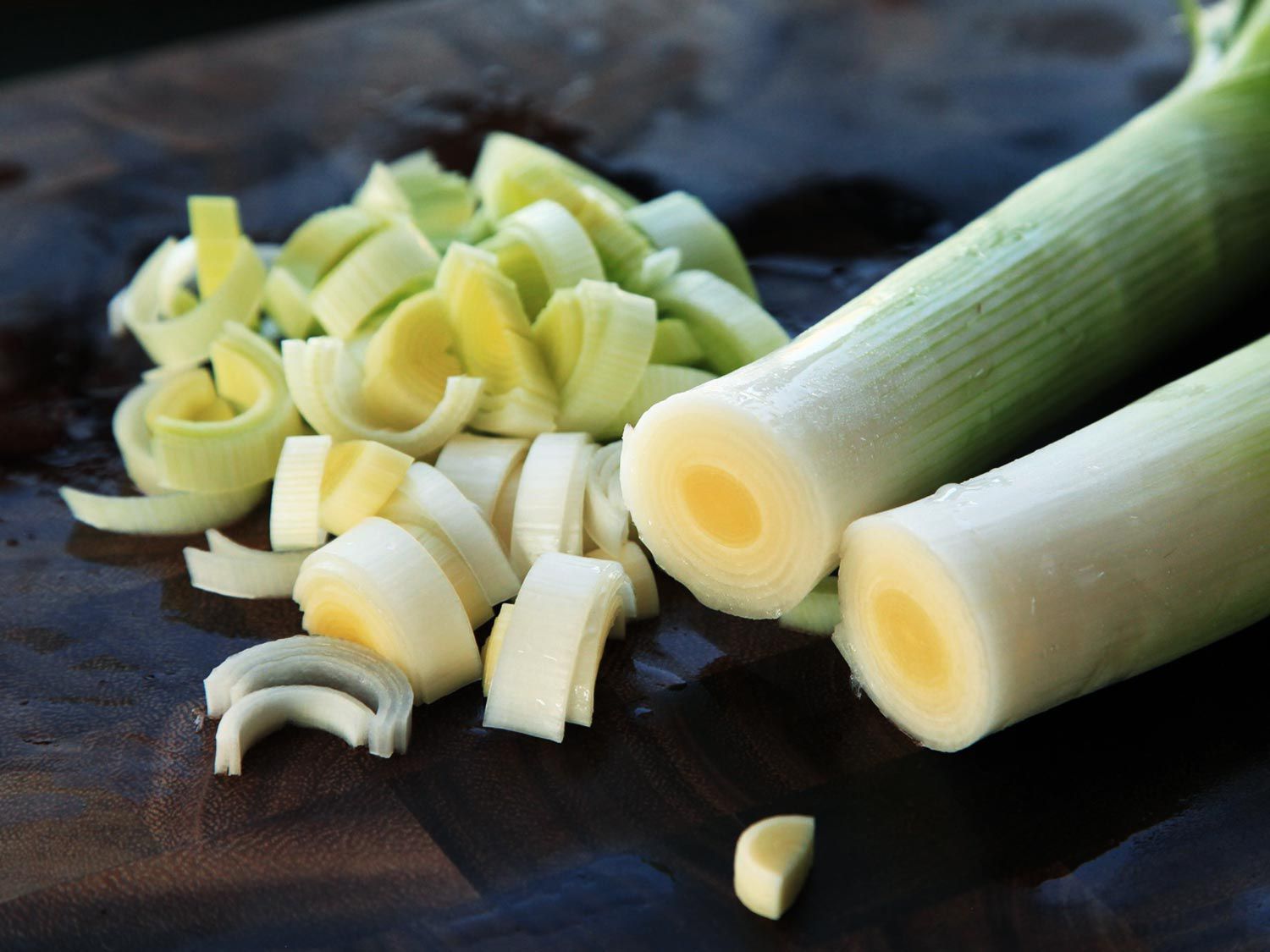 Freshly sliced leeks on a black surface. 