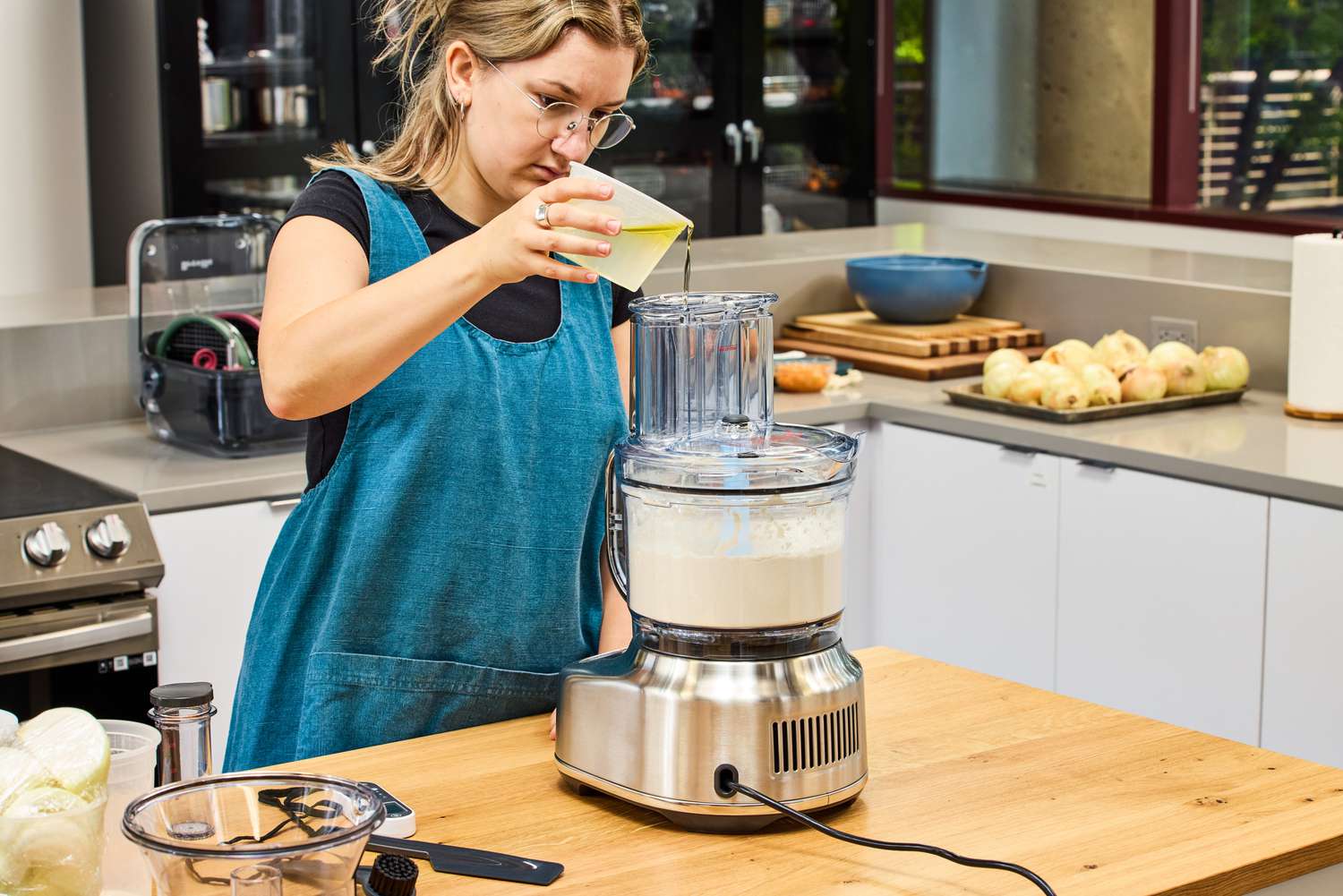 A person pours liquid into the Breville BFP838BSS1BNA1 16-Cup Paradice Food Processor