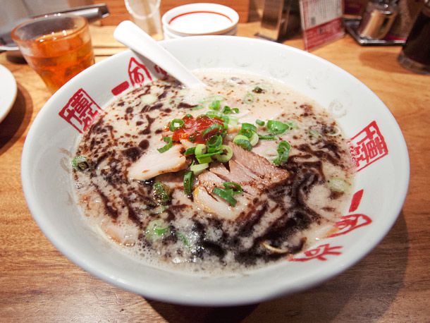 Tonkotsu ramen with mayu in a bowl resting on a table. 