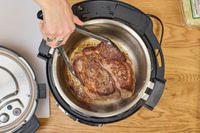 A person cooks meat in the Instant Pot Pro Plus Wi-Fi Smart 10-in-1 6-Quart Pressure Cooker