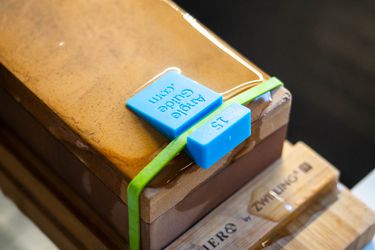 A small plastic 15-degree angle guide is rubber banded to the end of a whetstone
