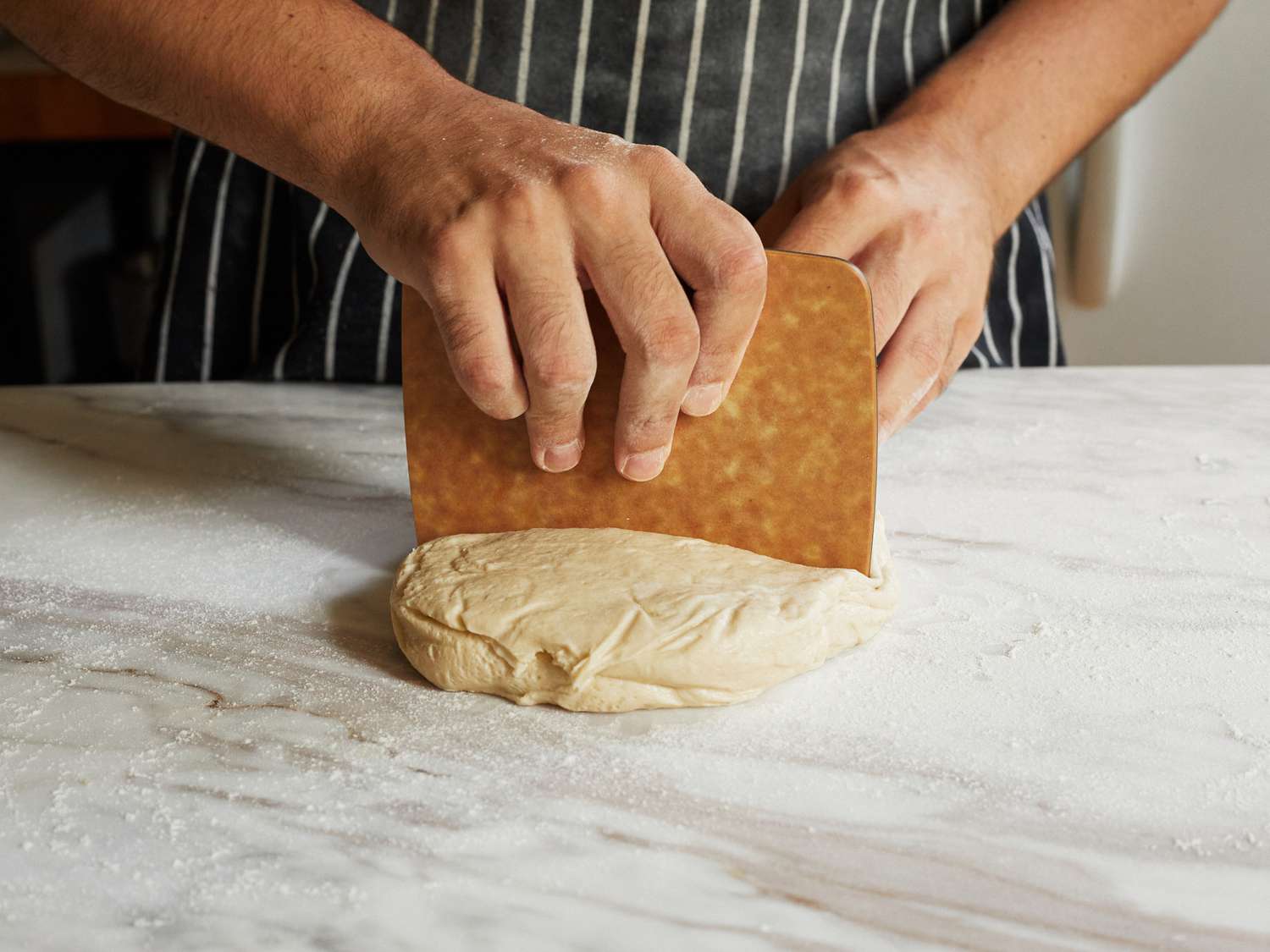 using the wooden epicurean bench scraper to cut pizza dough