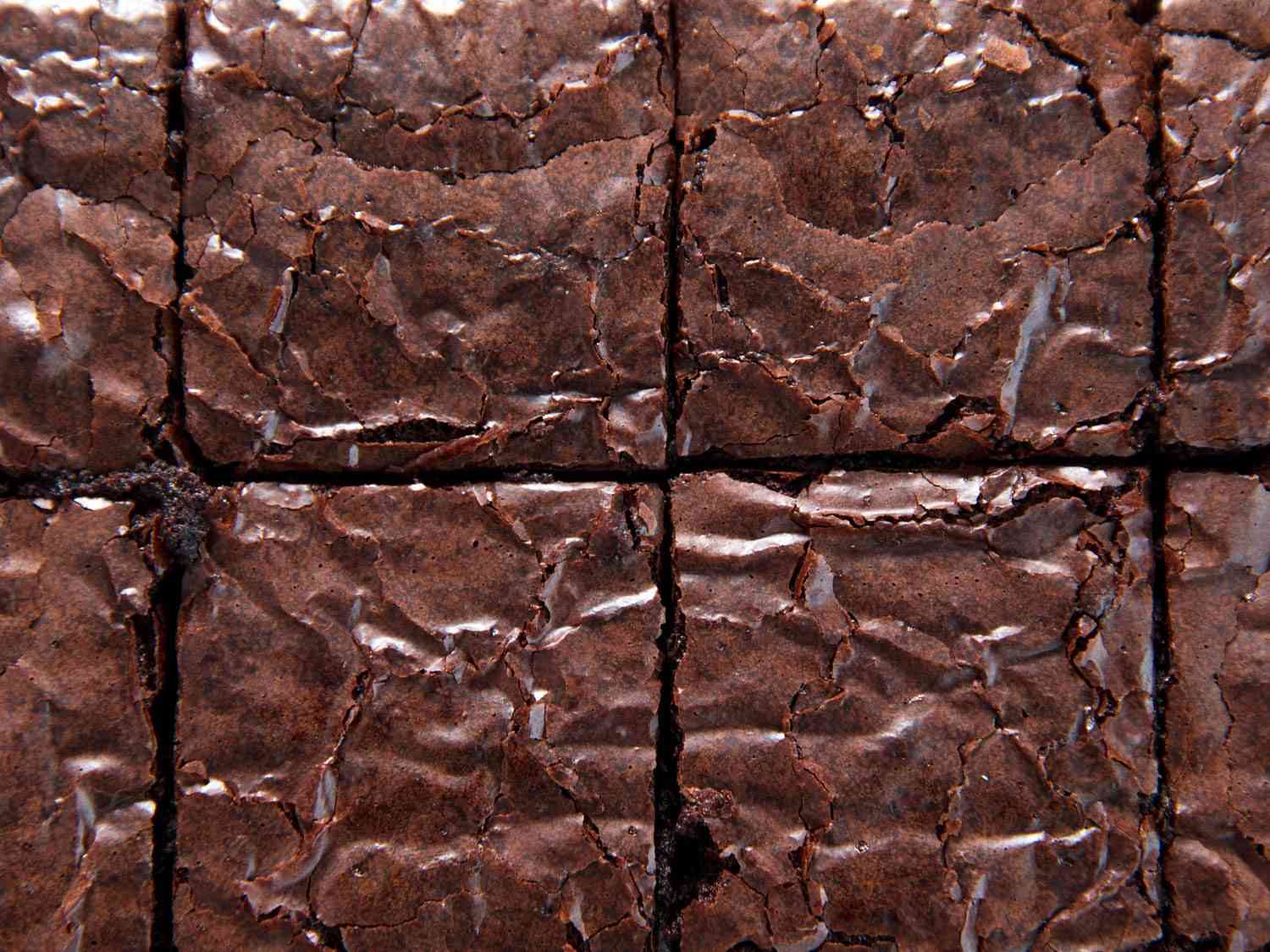 Close-up of a glossy and crackly crust of a baked brownie.