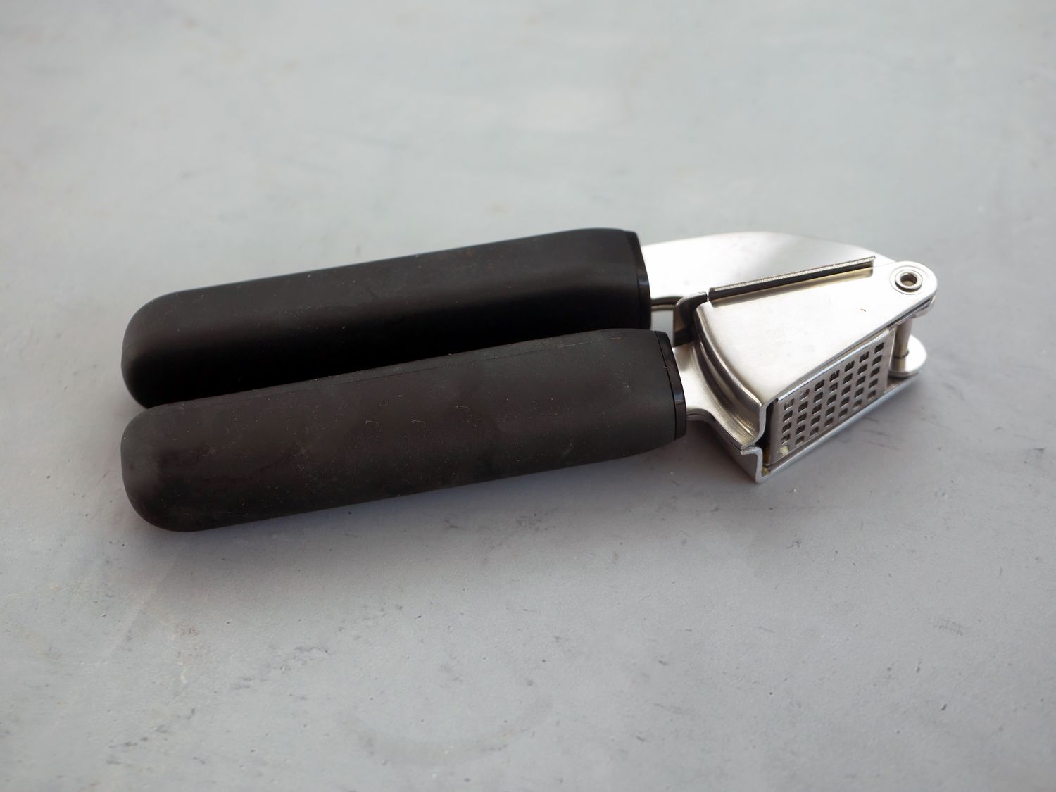 oxo garlic press on a gray surface