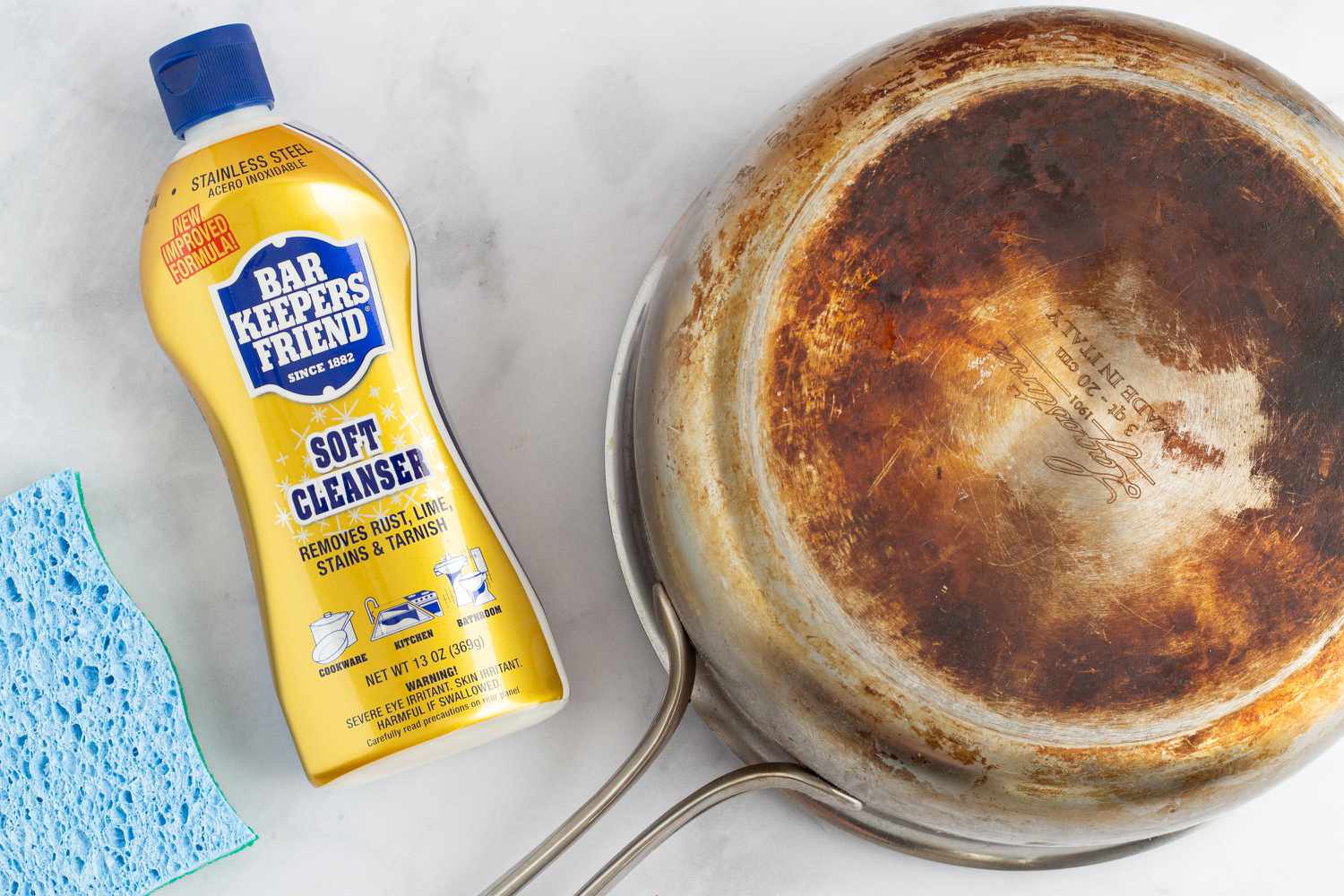 Bar Keepers Friend on counter top with pan and sponge