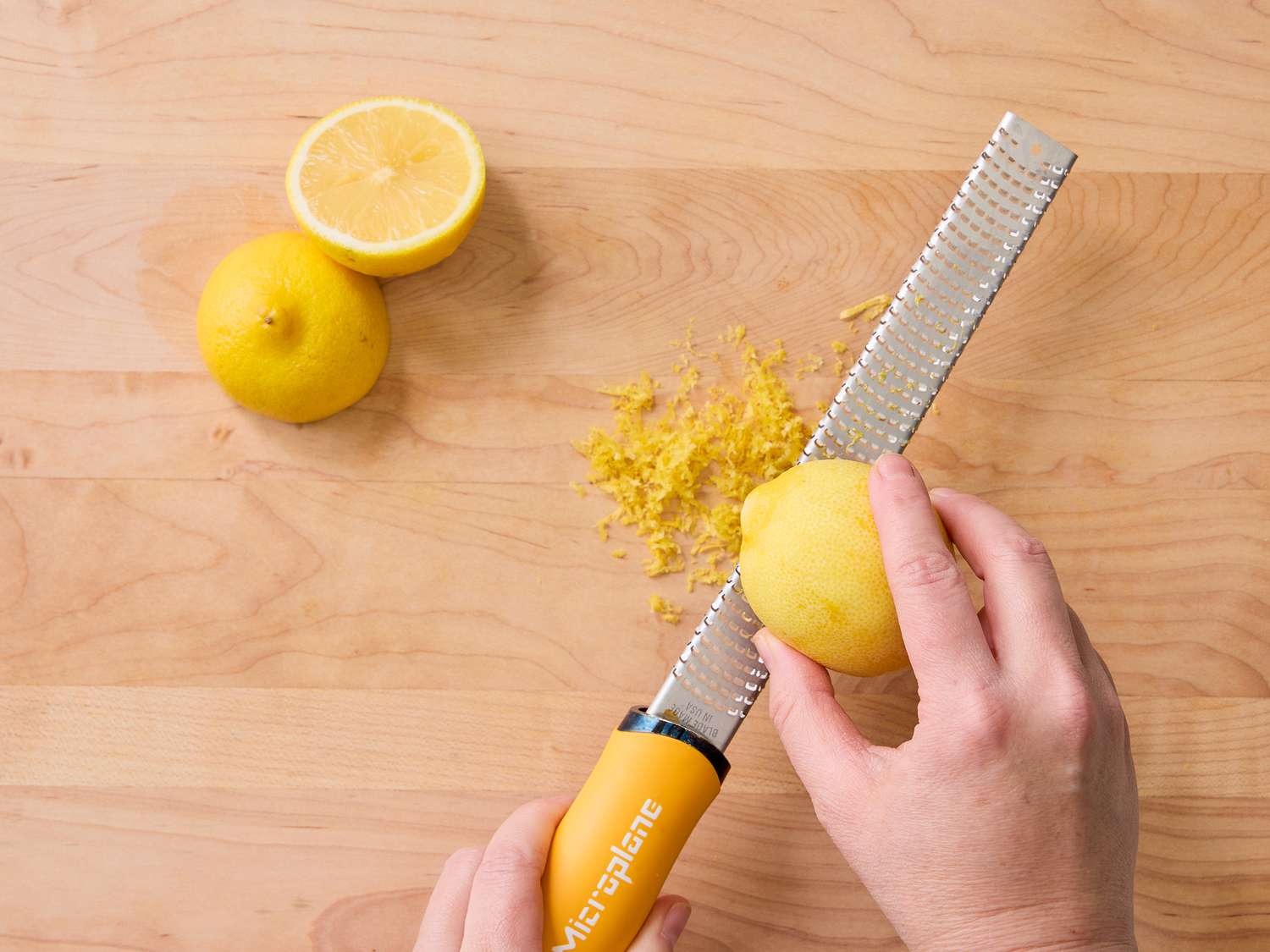 Zesting a lemon with a microplane grater 