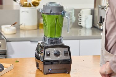 The Vitamix Propel 510 blender filled with green liquid, on a kitchen counter