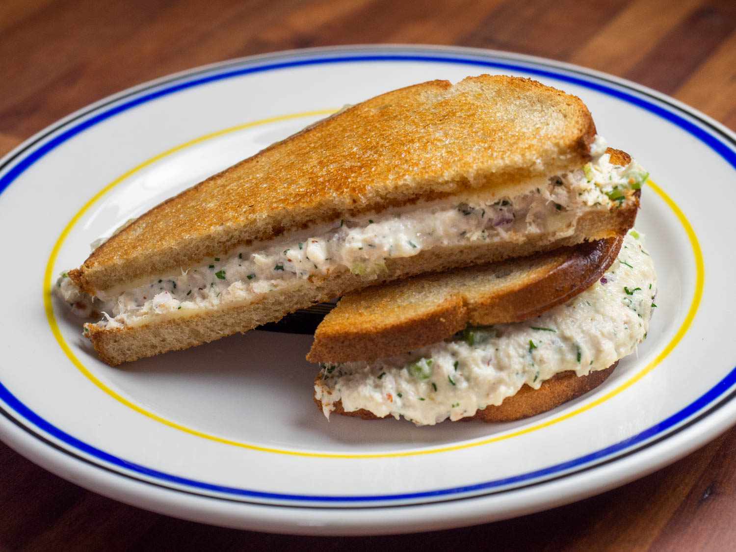 A tuna melt on rye with melted Swiss cheese on a plate