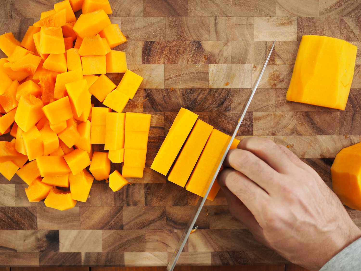 Rectangles of butternut squash being cut.
