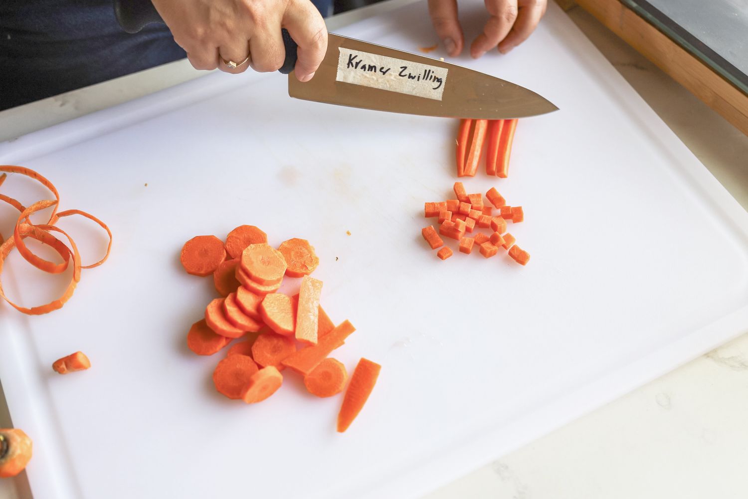 A person chopping carrots with a knife