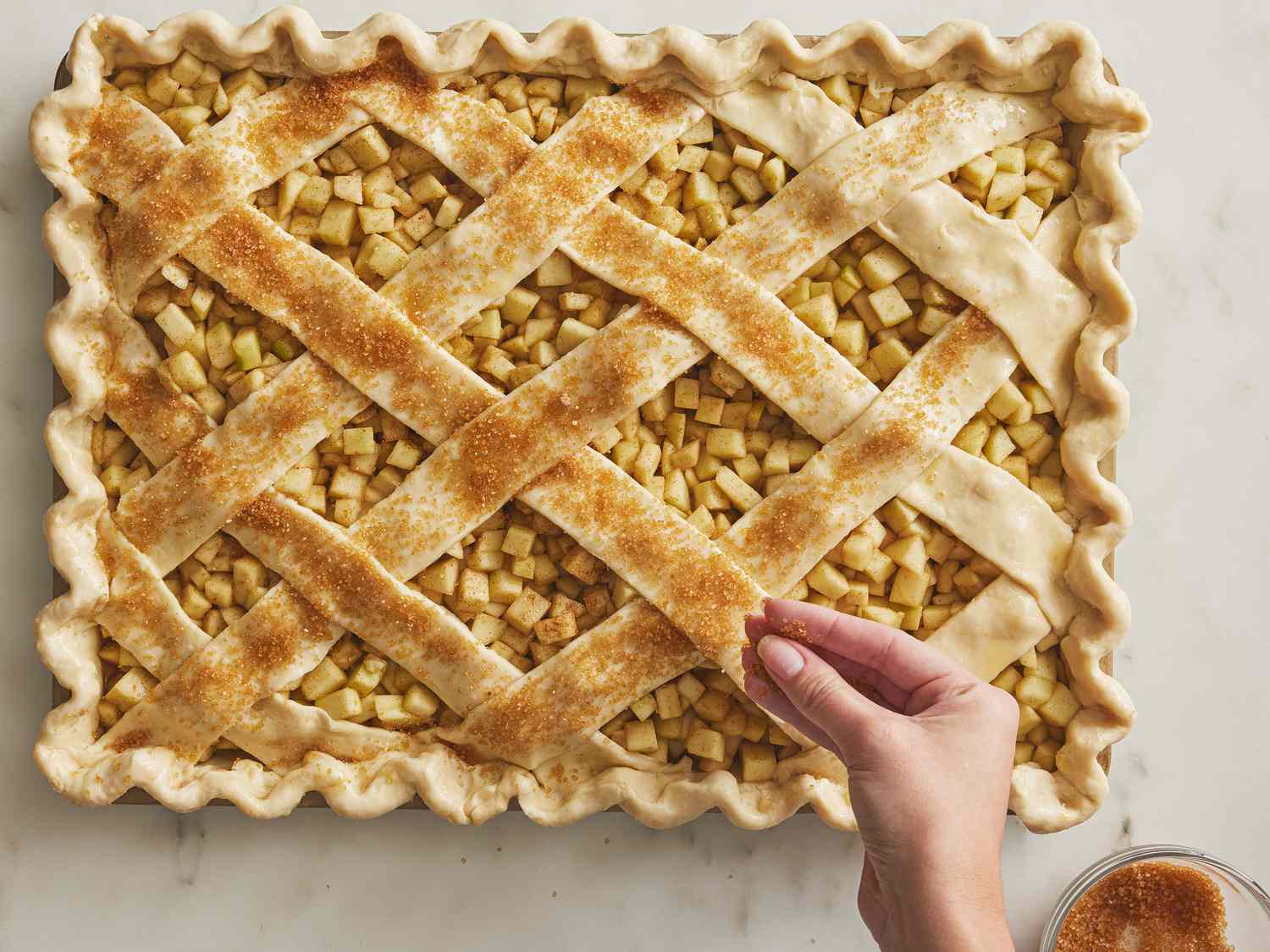sprinkling arranged pie with turbinado sugar 