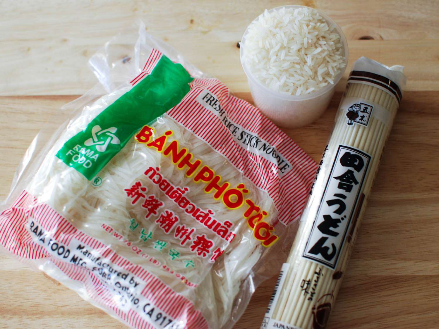 Packages of noodles and a cup of white rice for Chinese hot pot.