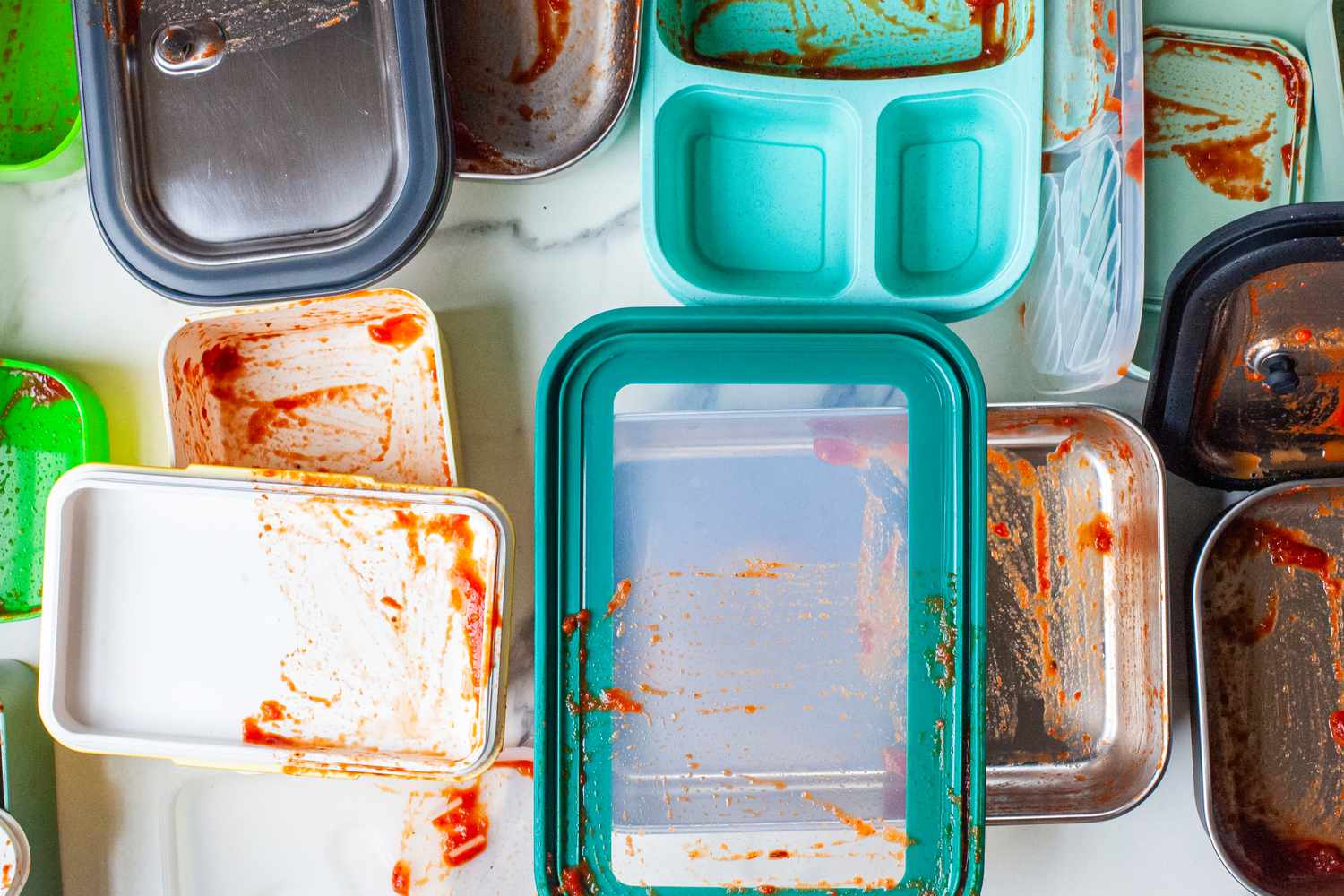 a bunch of bento boxes smeared with spaghetti sauce