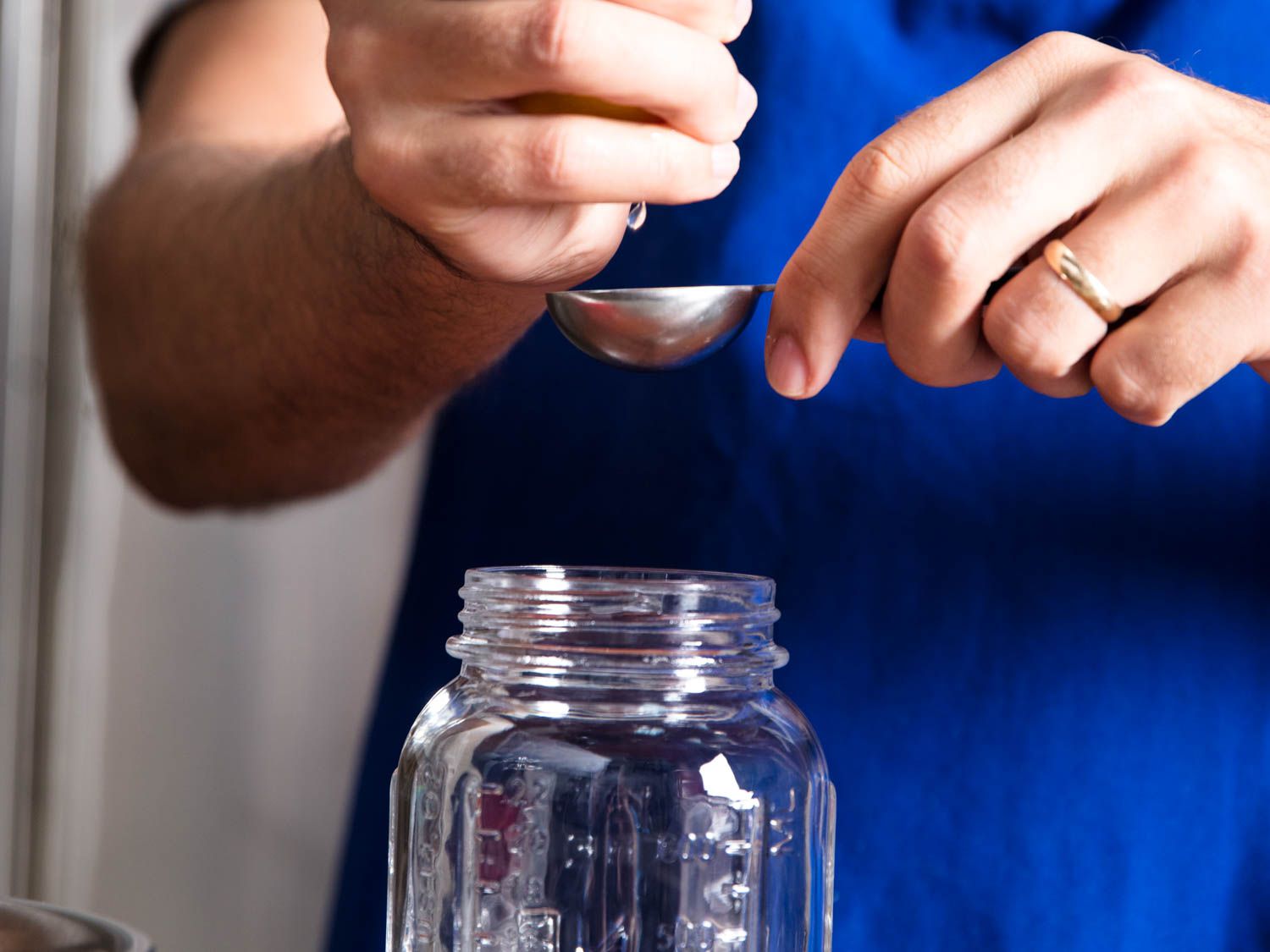 Using a tablespoon to add acid to a jar for canning tomatoes