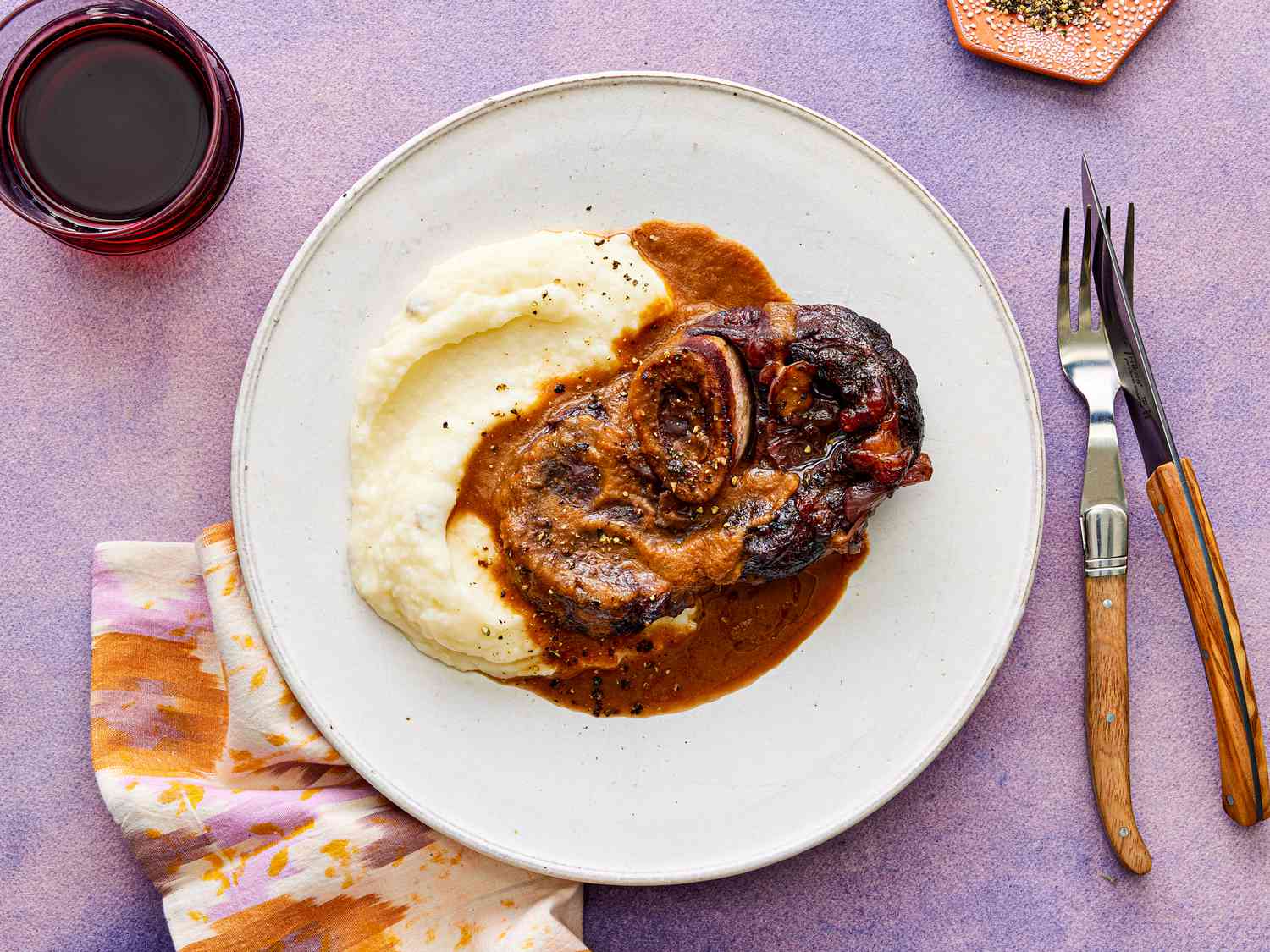 Overhead view of red-wine braised short ribs on a white plate