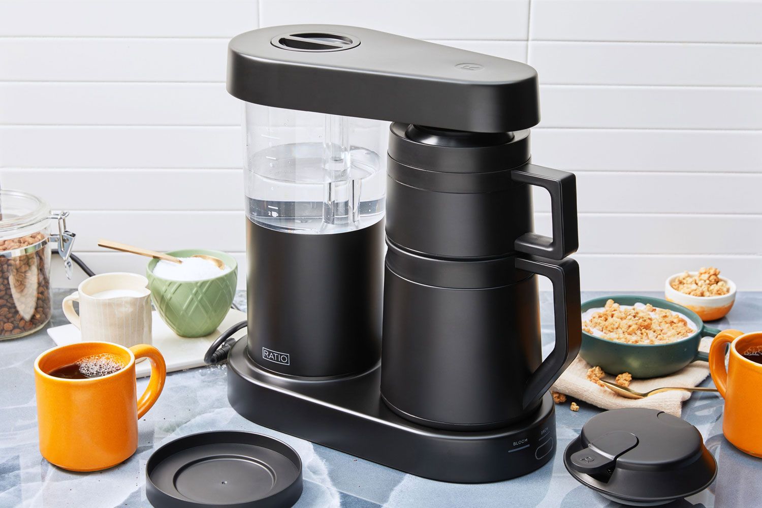 The Ratio Six Coffee Maker on a counter next to coffee and cereal.